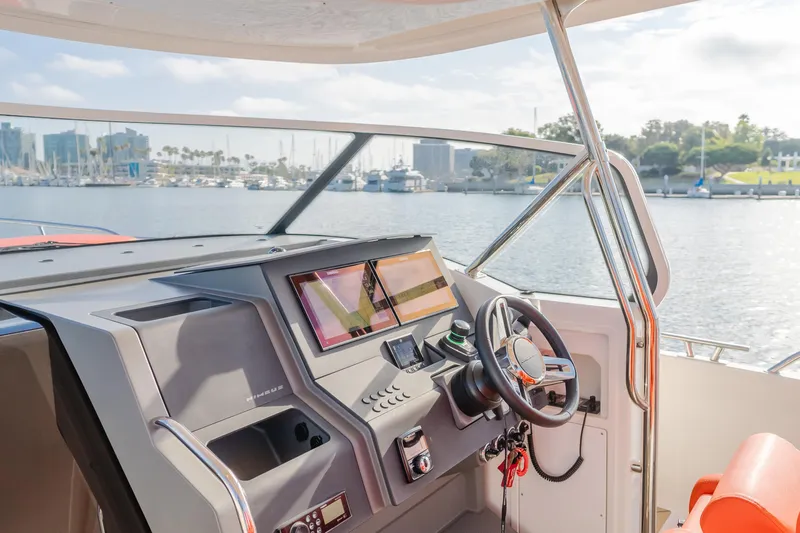 Intrepid Yacht Photos Pics Cockpit of 2021 Nimbus T11 boat with modern controls, overlooking marina.