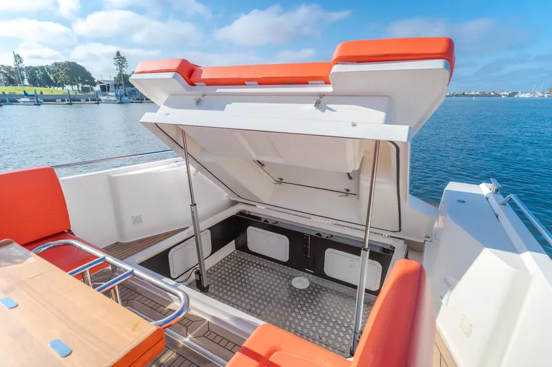 Intrepid Yacht Photos Pics Open storage compartment on a 2021 Nimbus T11 boat, docked by a scenic waterfront.