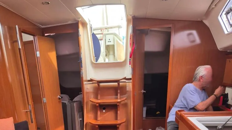 1702 Yacht Photos Pics Interior of 2010 Beneteau Oceanis 43 sailboat with wooden finish and person seated.