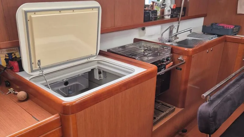 1702 Yacht Photos Pics Interior of 2010 Beneteau Oceanis 43 yacht kitchen with open fridge, stove, and sink.
