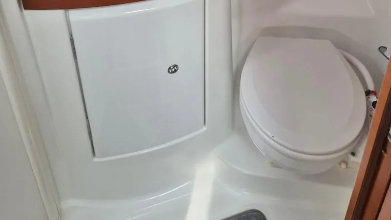 1702 Yacht Photos Pics Beneteau Oceanis 43 (2010) yacht bathroom with white toilet and storage cabinet.