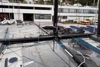 Sailboat deck with rigging, GC 32 model, 2012, docked near modern buildings.