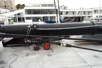 Sailboat mast and rigging on dock, GC 32 model, 2012, with modern building background.