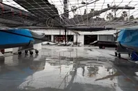 Wet marina floor with boats and netting, GC 32 model, 2012, palm trees in background.