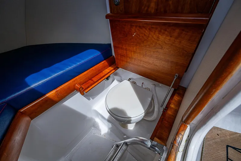 Candy Ride Yacht Photos Pics Interior of 2011 Winter Custom Yachts 29, featuring a compact marine toilet and wooden accents.