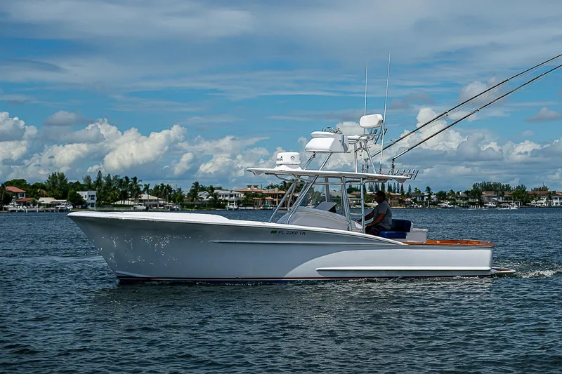 Candy Ride Yacht Photos Pics 2011 Winter Custom Yachts 29 cruising on a calm, scenic waterway under a blue sky.