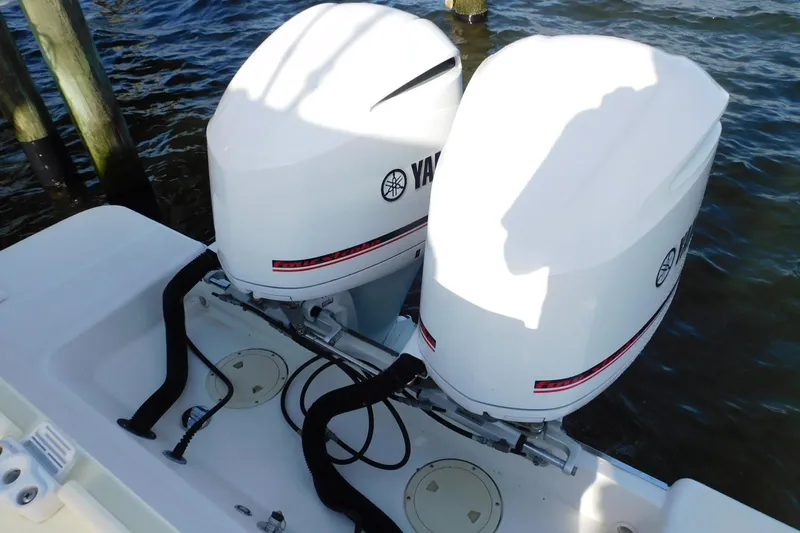 Happily Ever After Yacht Photos Pics Twin Yamaha outboard engines on a 2016 Belzona 327 WA boat, docked by wooden posts.