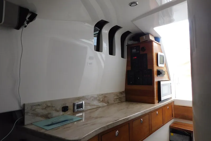 Happily Ever After Yacht Photos Pics Interior of 2016 Belzona 327 WA boat with modern kitchen and control panel.