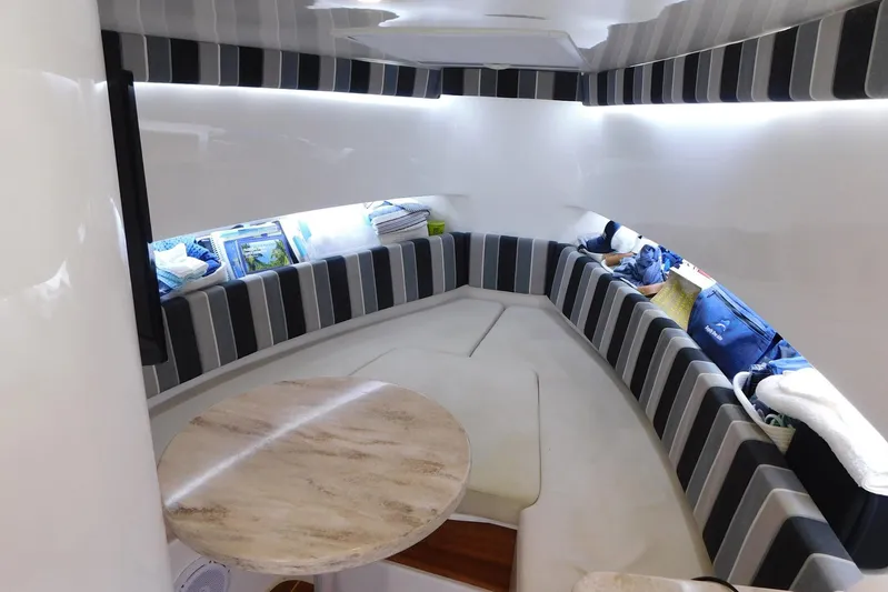 Happily Ever After Yacht Photos Pics 2016 Belzona 327 WA cabin interior with striped seating and round table.