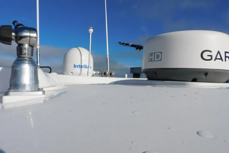 Happily Ever After Yacht Photos Pics Rooftop of 2016 Belzona 327 WA with Garmin and Intellian equipment under blue sky.