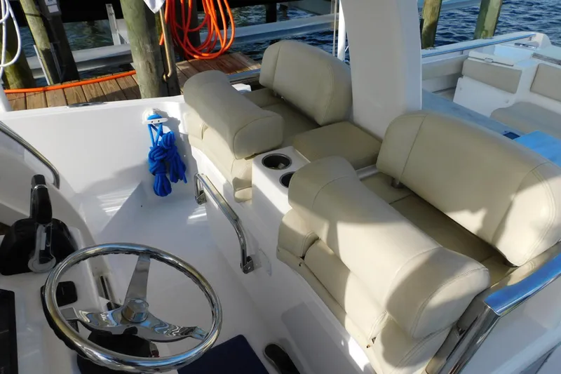 Happily Ever After Yacht Photos Pics 2016 Belzona 327 WA boat interior with beige seating and steering wheel.