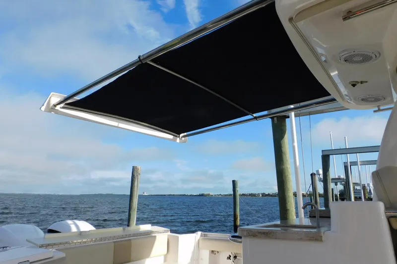 Happily Ever After Yacht Photos Pics 2016 Belzona 327 WA boat with extended black sunshade over water.