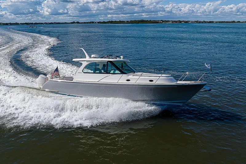  Yacht Photos Pics 2023 Hinckley 40x boat cruising on open water under a partly cloudy sky.