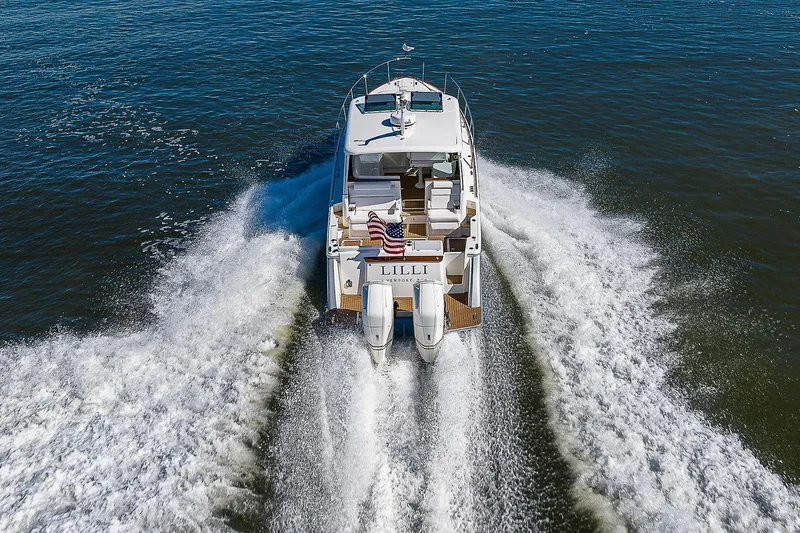  Yacht Photos Pics 2023 Hinckley 40x yacht cruising on open water, rear view with wake.