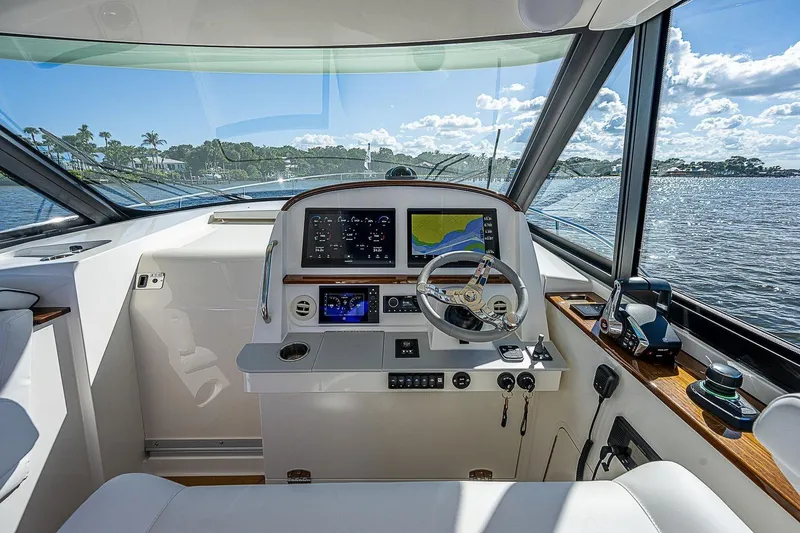  Yacht Photos Pics Helm of 2023 Hinckley 40x yacht with modern navigation equipment and scenic water view.