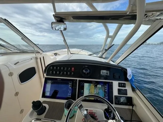 Texas Crewed Yacht Photos Pics 2024 Grady-White Freedom 335 boat cockpit with navigation screens, steering wheel, and ocean view.