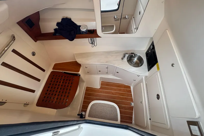 Texas Crewed Yacht Photos Pics 2024 Grady-White Freedom 335 cabin interior with sink, wooden flooring, and storage.