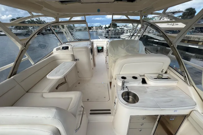 Texas Crewed Yacht Photos Pics 2024 Grady-White Freedom 335 boat interior with seating, sink, and marina view.