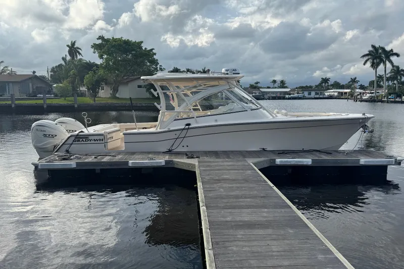 Texas Crewed Yacht Photos Pics 2024 Grady-White Freedom 335 boat docked on a calm waterfront.