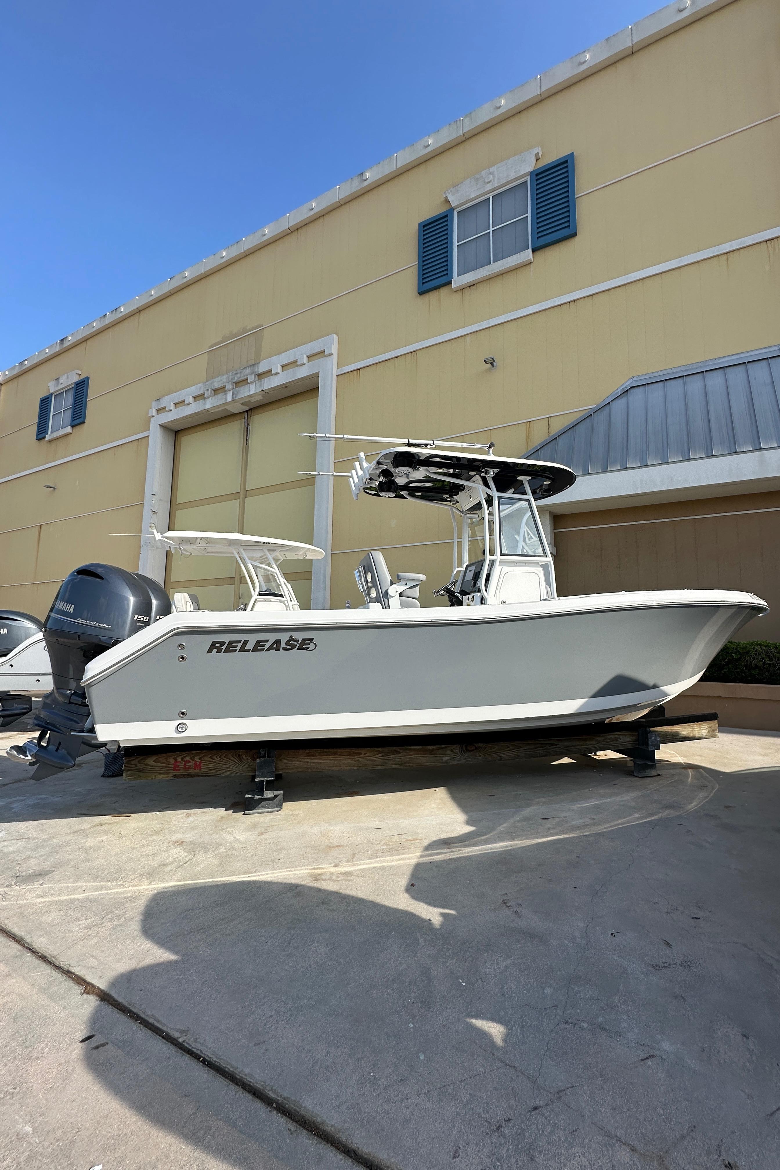 2021 Release 240 RX boat on trailer, parked outside a yellow building.