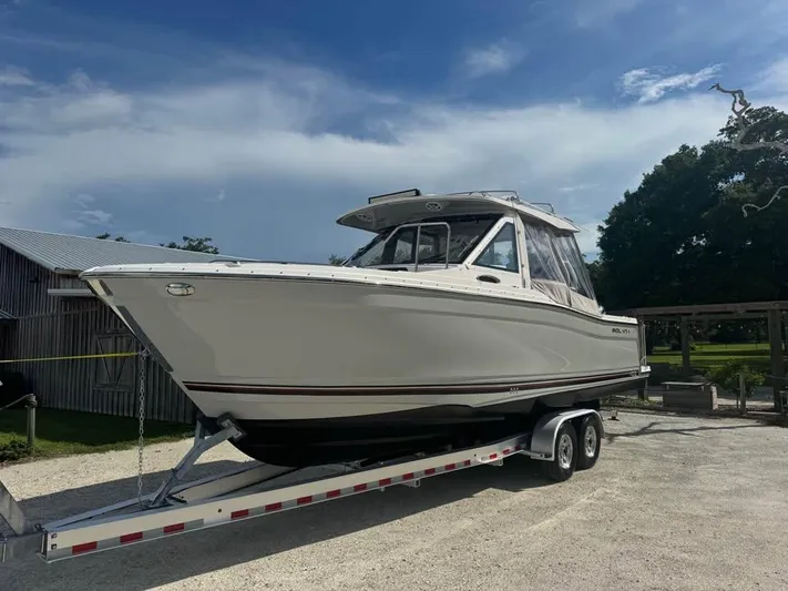  Yacht Photos Pics 2023 Solara S-310 CW boat on trailer, parked outdoors under a clear sky.