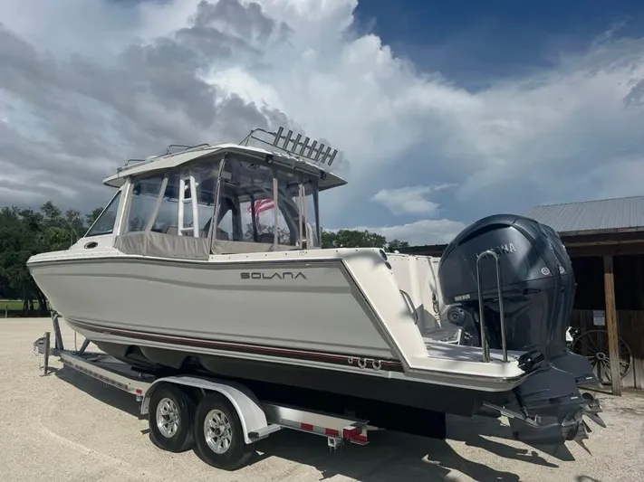  Yacht Photos Pics 2023 Solara S-310 CW boat on trailer under cloudy sky.