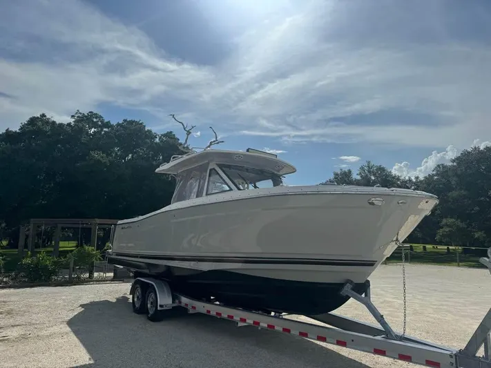  Yacht Photos Pics 2023 Solara S-310 CW boat on trailer under sunny sky.