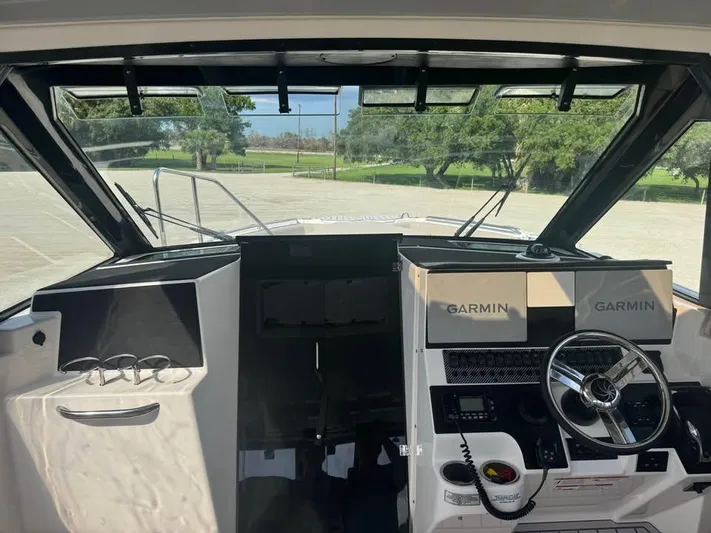  Yacht Photos Pics 2023 Solara S-310 CW boat cockpit with Garmin navigation system and steering wheel.