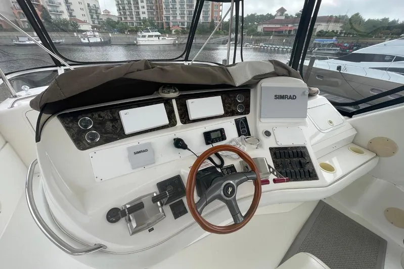 Double Kickback IV Yacht Photos Pics 1998 Sea Ray 480 Sedan Bridge helm with Simrad electronics and wooden steering wheel.