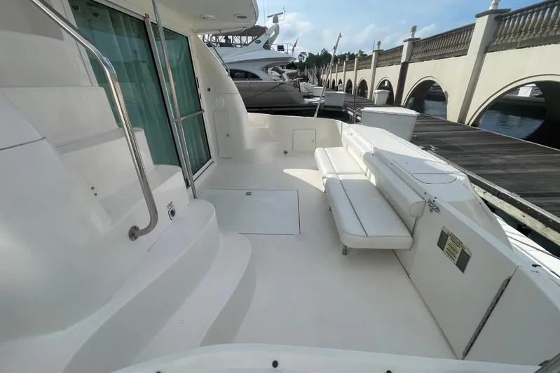 Double Kickback IV Yacht Photos Pics 1998 Sea Ray 480 Sedan Bridge yacht deck with seating, docked by a marina.