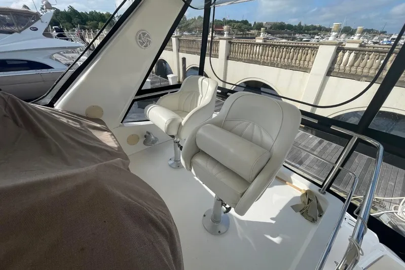 Double Kickback IV Yacht Photos Pics 1998 Sea Ray 480 Sedan Bridge interior with white leather seats at marina.