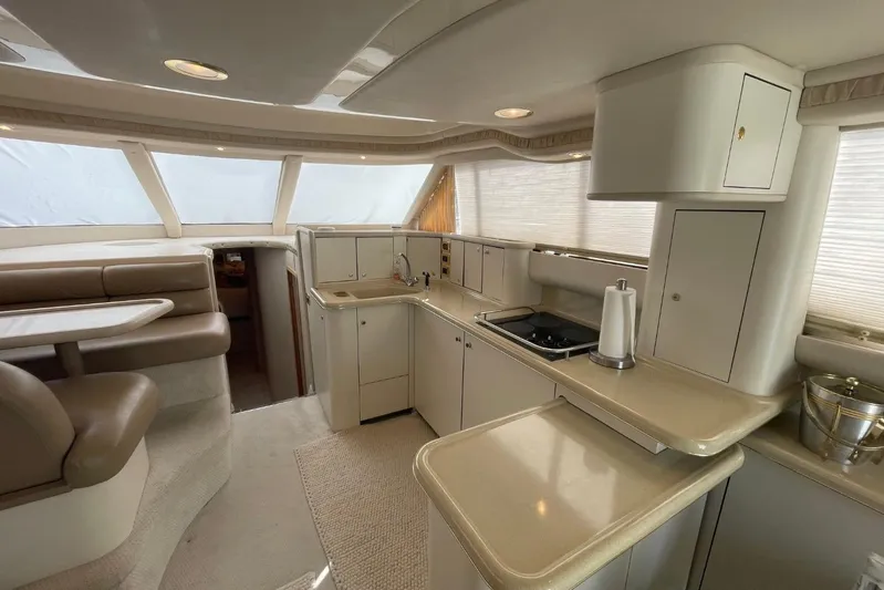 Double Kickback IV Yacht Photos Pics 1998 Sea Ray 480 Sedan Bridge interior with kitchen and dining area.