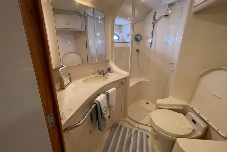 Double Kickback IV Yacht Photos Pics Luxurious bathroom in 1998 Sea Ray 480 Sedan Bridge yacht, featuring shower and vanity.