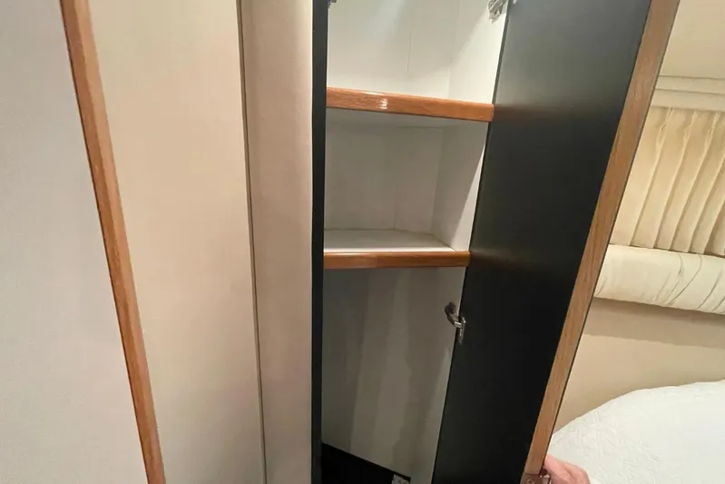 Double Kickback IV Yacht Photos Pics Open cabinet with wooden shelves inside a 1998 Sea Ray 480 Sedan Bridge yacht.