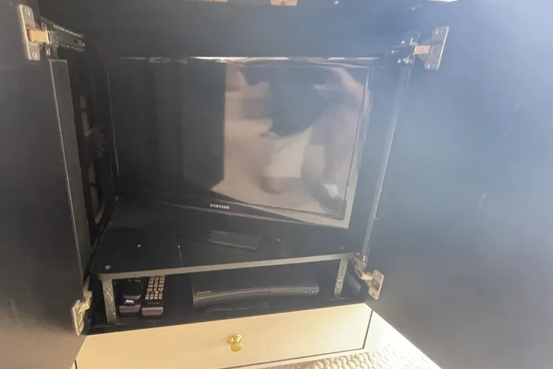 Double Kickback IV Yacht Photos Pics Cabinet with Samsung TV and remote controls on a 1998 Sea Ray 480 Sedan Bridge.