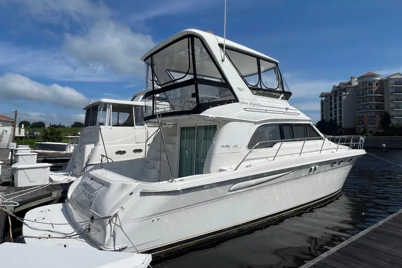 Double Kickback IV Yacht Photos Pics 1998 Sea Ray 480 Sedan Bridge yacht docked at marina under blue sky.