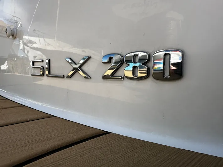  Yacht Photos Pics Close-up of 2023 Sea Ray 280 SLX boat emblem on white hull.