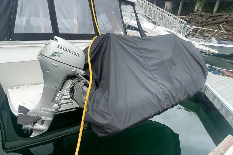  Yacht Photos Pics 1989 Bayliner Pilothouse 4588 with Honda outboard motor, docked and covered.