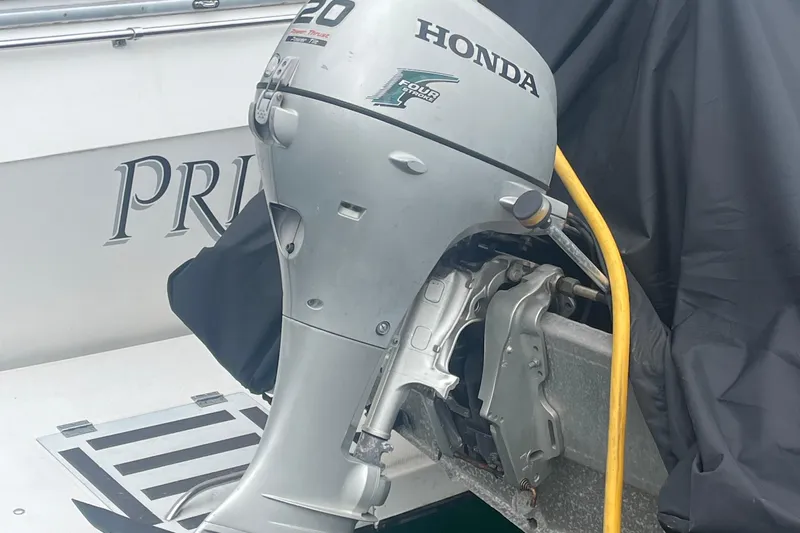  Yacht Photos Pics Honda outboard motor on a 1989 Bayliner Pilothouse 4588 boat, partially covered.