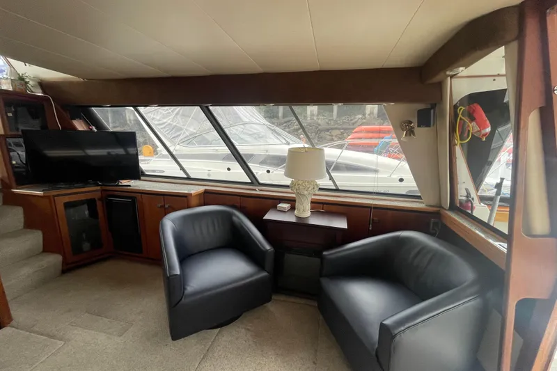  Yacht Photos Pics Interior of 1989 Bayliner Pilothouse 4588 with seating, TV, and large windows.