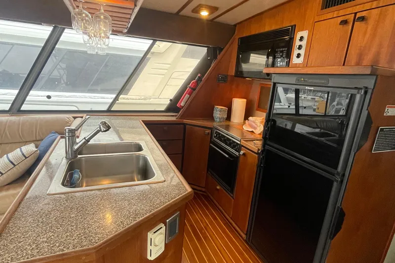  Yacht Photos Pics Interior of 1989 Bayliner Pilothouse 4588, featuring kitchen with sink, stove, and refrigerator.