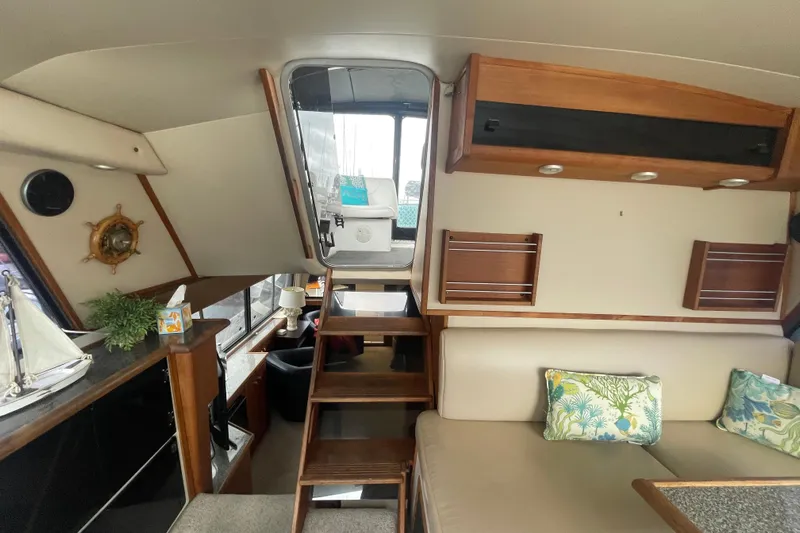  Yacht Photos Pics Interior of 1989 Bayliner Pilothouse 4588 with stairs, seating, and nautical decor.