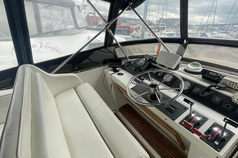  Yacht Photos Pics 1989 Bayliner Pilothouse 4588 helm with steering wheel, controls, and navigation equipment.
