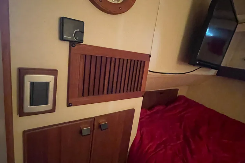  Yacht Photos Pics Interior of 1989 Bayliner Pilothouse 4588 with wood paneling and red bedding.