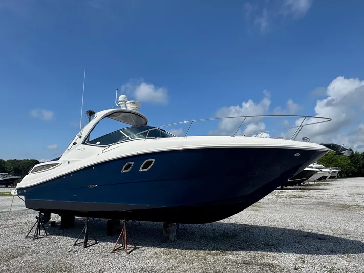 Max Dream Yacht Photos Pics 2014 Sea Ray 330 Sundancer boat on stands under a clear blue sky.
