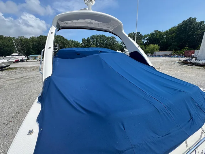 Max Dream Yacht Photos Pics 2014 Sea Ray 330 Sundancer covered with blue tarp in outdoor storage area.