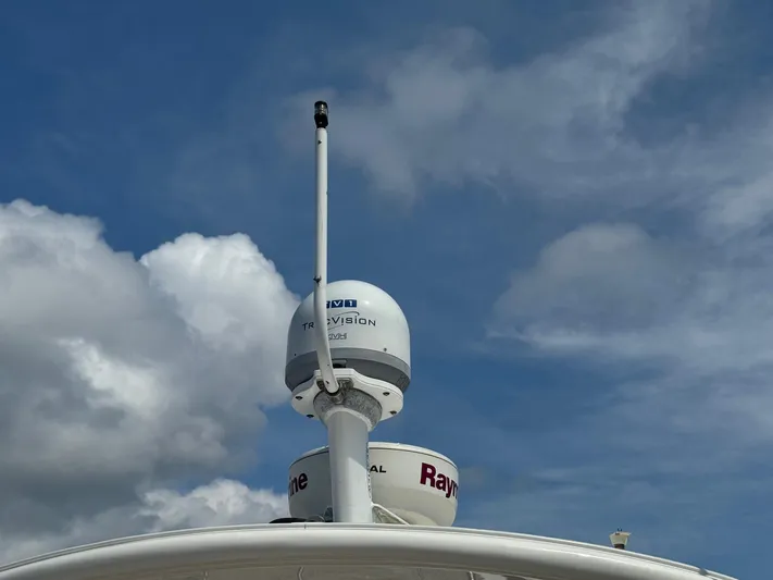 Max Dream Yacht Photos Pics Radar and satellite equipment on a 2014 Sea Ray 330 Sundancer against a cloudy sky.