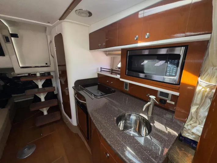 Max Dream Yacht Photos Pics 2014 Sea Ray 330 Sundancer interior with kitchenette, microwave, and wooden cabinetry.