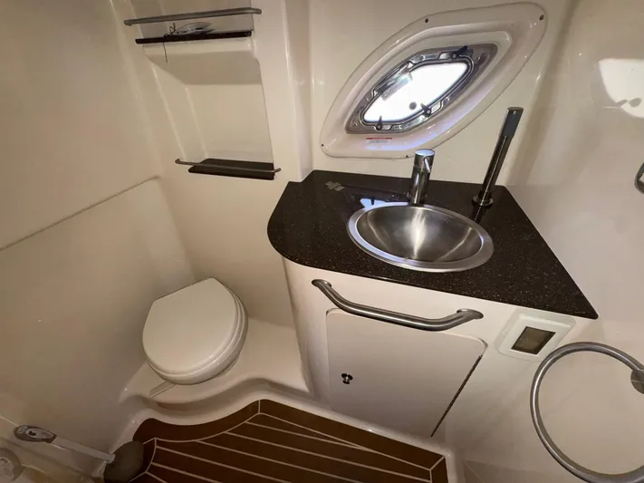 Max Dream Yacht Photos Pics 2014 Sea Ray 330 Sundancer bathroom with sink, toilet, and porthole window.