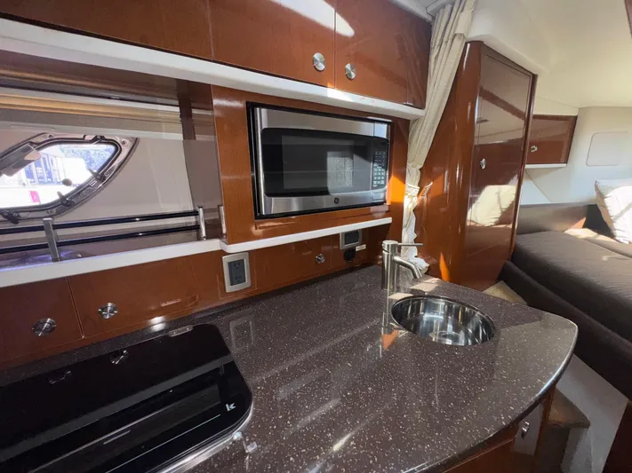 Max Dream Yacht Photos Pics 2014 Sea Ray 330 Sundancer interior with kitchenette, microwave, and sink.